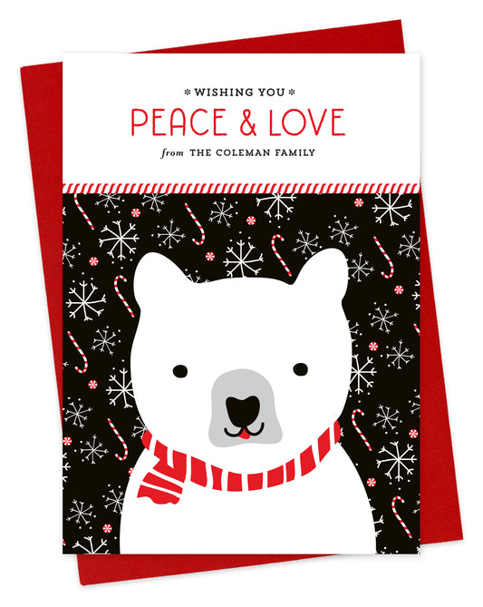 Customizable paper holiday card featuring a polar bear on a festive black background, “Wishing you Peace & Love” sentiment and a personal greeting. Shown with a red envelope.