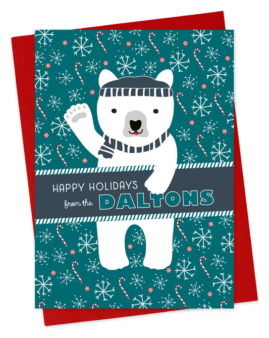 Customizable paper holiday card featuring a waving polar bear in a beanie and scarf against an aqua background with candy canes and snowflakes. A banner across the middle displays a personal greeting. Shown with a red envelope.