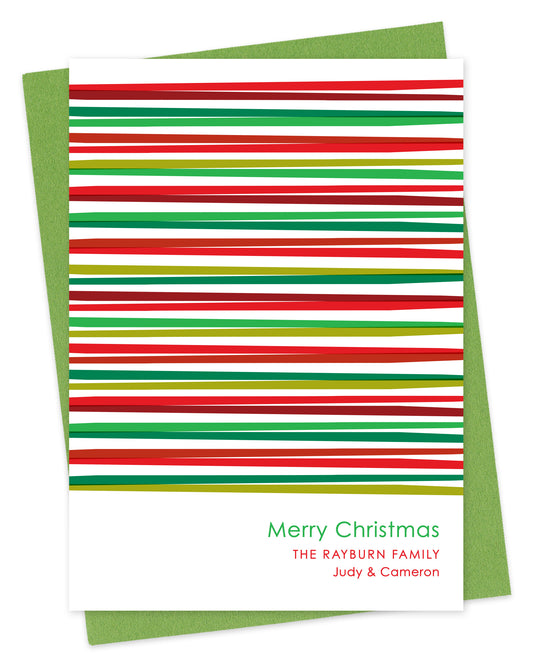 Customizable paper Christmas card with horizontal stripes in various shades of red and green and a personal greeting on a white background. Shown with a green envelope.