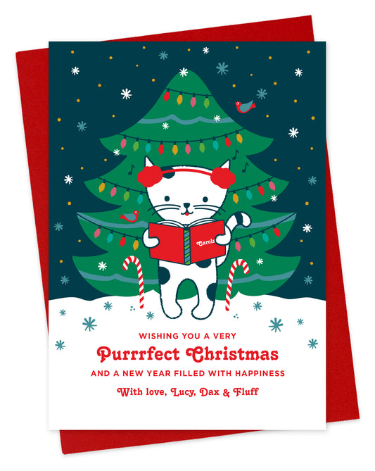 Customizable paper holiday card featuring a cute cat caroling in front of a decorated outdoor Christmas tree, "Wishing you a Very Purrrfect Christmas" text and a personal greeting at the bottom. Shown with a red envelope.