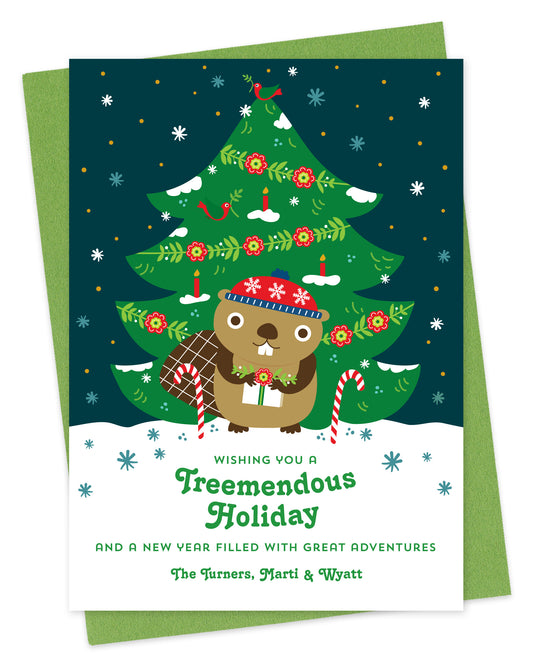 Customizable paper holiday card featuring a cute beaver holding a gift in front of a decorated outdoor Christmas tree, "Wishing you a Treemendous Holiday" text and a personal greeting at the bottom. Shown with a green envelope.