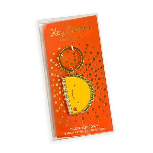 Taco Tuesday enamel keychain on gold foil stamped backer card packaged in a clear gift box. Backer card reads "Key Charm Enamel Keychain" at top and "Taco Tuesday by Night Owl Paper Goods" at bottom.