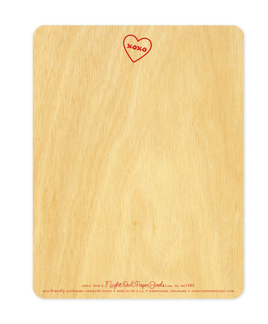 Back of XOXO wood love card, which features a small heart with "XOXO" text inside at the top and space beneath to handwrite a personal greeting. The company logo and text that reads "eco-friendly sustainably harvested wood - made in the usa - birmingham, owlabama - nightowlpapergoods.com" runs along the bottom.