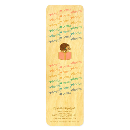 Back side of hedgehog bookmark with cute illustration of hedgehog standing on the top of a pink book. Pastel pattern with text reads 'I heart books'.