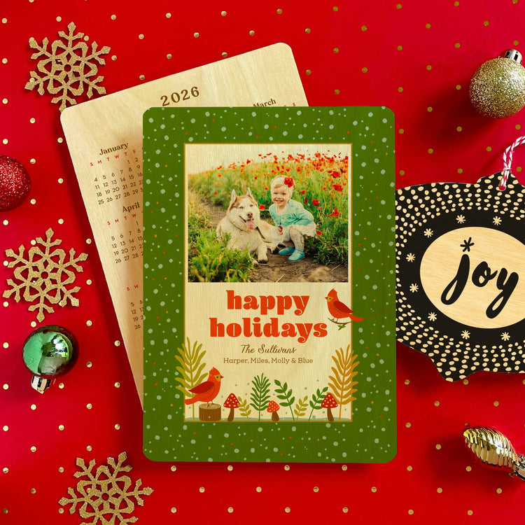 Custom wood holiday card featuring a family photo, cute red birds in green woodland setting and shows back of card with keepsake calendar.