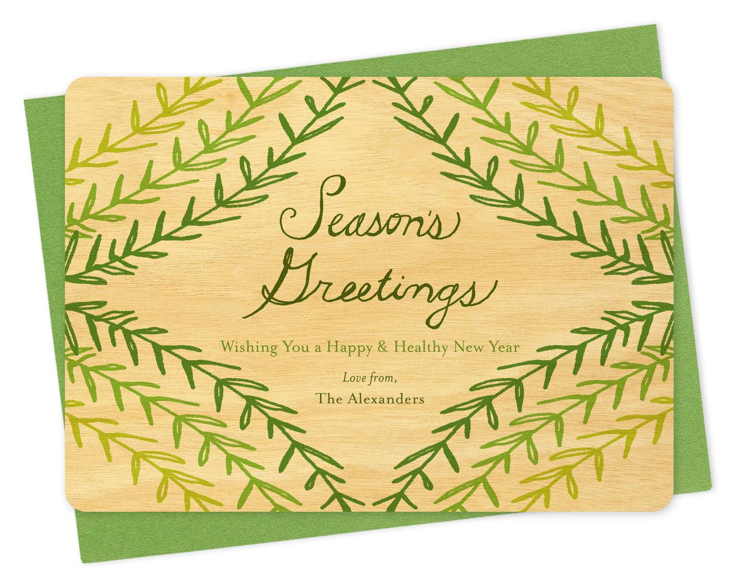 Customizable wood holiday card with green sprig design, "Season's Greetings" sentiment and a personal message on a birch wood card. Shown with a green envelope.