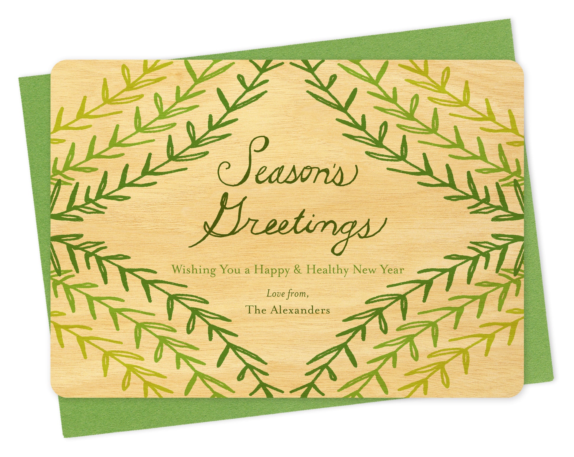 Customizable wood holiday card with green sprig design, "Season's Greetings" sentiment and a personal message on a birch wood card. Shown with a green envelope.