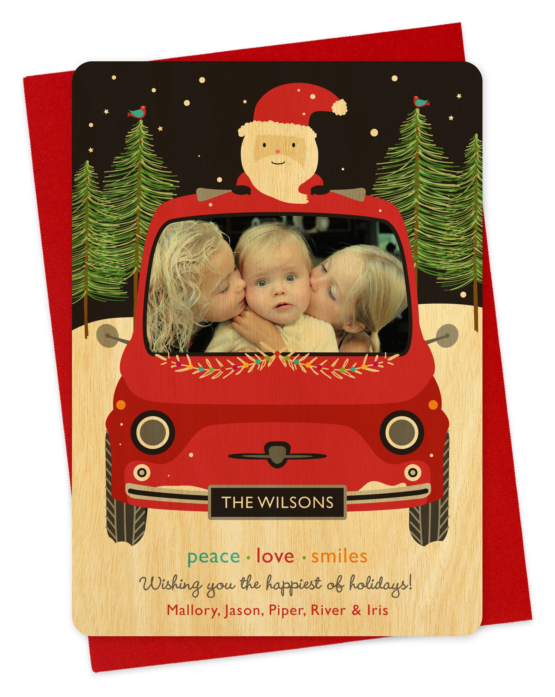 Customizable wood holiday card featuring your photo in the windshield of a red car with santa riding on top. Features family name on the license plate and a personal greeting at the bottom of the card. Shown on a red envelope.