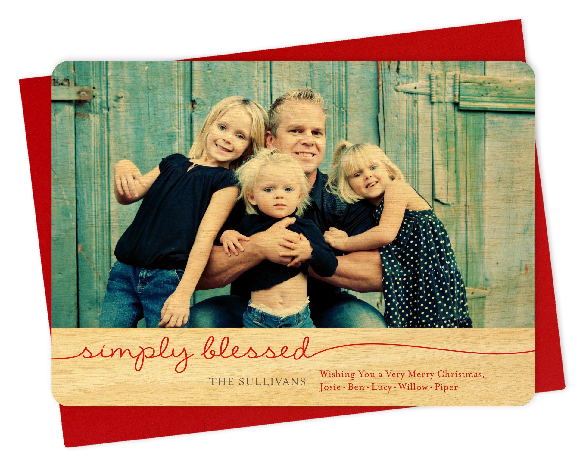 Customizable wood holiday card featuring a family photo and a birch wood grain border at the bottom that reads "simply blessed" along with a personal greeting. Shown with a red envelope.