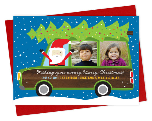Customizable paper holiday card featuring your family photos in the windows of a wood-paneled station wagon with Santa driving and a personal greeting on the side of the car. Shown with a red envelope.