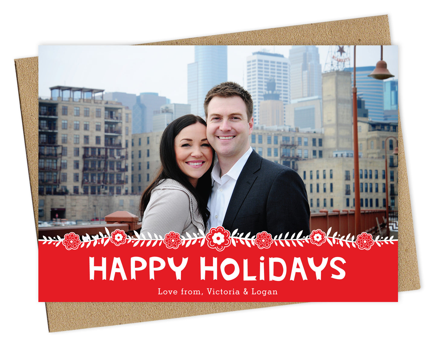 Customizable paper holiday card featuring a photo across the top, Scandinavian-inspired florals, and a red banner that reads “Happy Holidays.” Shown with a kraft envelope.