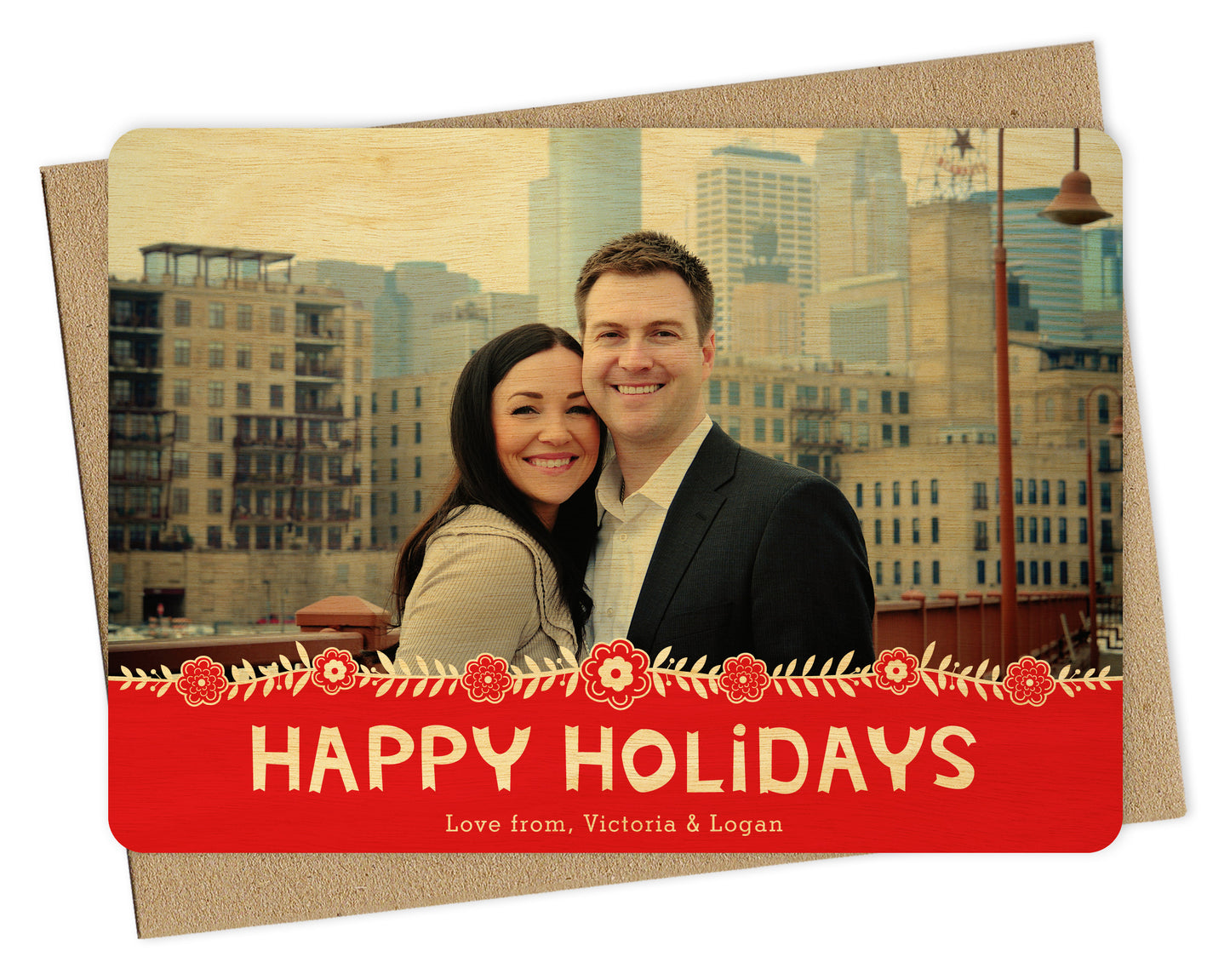 Customizable wood holiday card featuring a photo across the top, Scandinavian-inspired florals, and a red banner that reads “Happy Holidays.” Shown with a kraft envelope.
