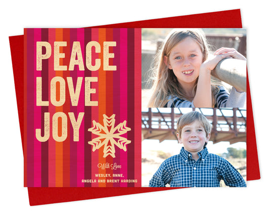 Customizable paper holiday card featuring 2 photos on the right and colorful vertical stripes with “PEACE LOVE JOY” text, a snowflake and a personal greeting on the left. Shown with a red envelope.