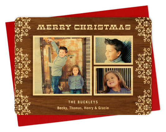 Customizable wood holiday card featuring 3 photos framed by printed walnut wood grain, festive doilies, "Merry Christmas” text at the top and a personal greeting near the bottom. Shown with a red envelope.