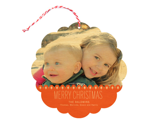 Front of customizable birch wood holiday ornament card featuring a photo with a red sparkle border, “Merry Christmas” text and a personal message. Round ornament with scalloped edges.