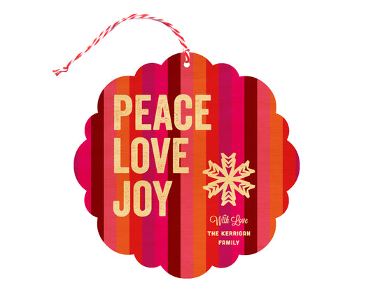 Front of customizable birch wood holiday ornament card featuring bright, colorful stripes, "Peace Love Joy" text, a snowflake and a personal message. Round ornament with scalloped edges.