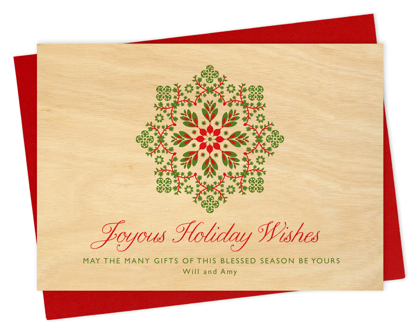 Customizable paper holiday card featuring a red and green snowflake on a printed birch wood grain background with a personal greeting. Shown with a red envelope.