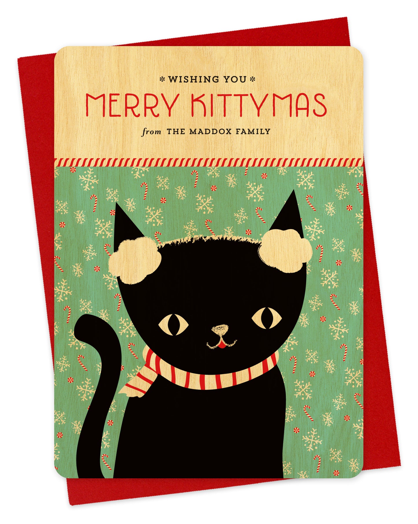 Customizable birch wood holiday card featuring a black cat wearing earmuffs in front of a festive backdrop, a "Merry Kittymas" sentiment and a personal greeting. Shown with a red envelope.