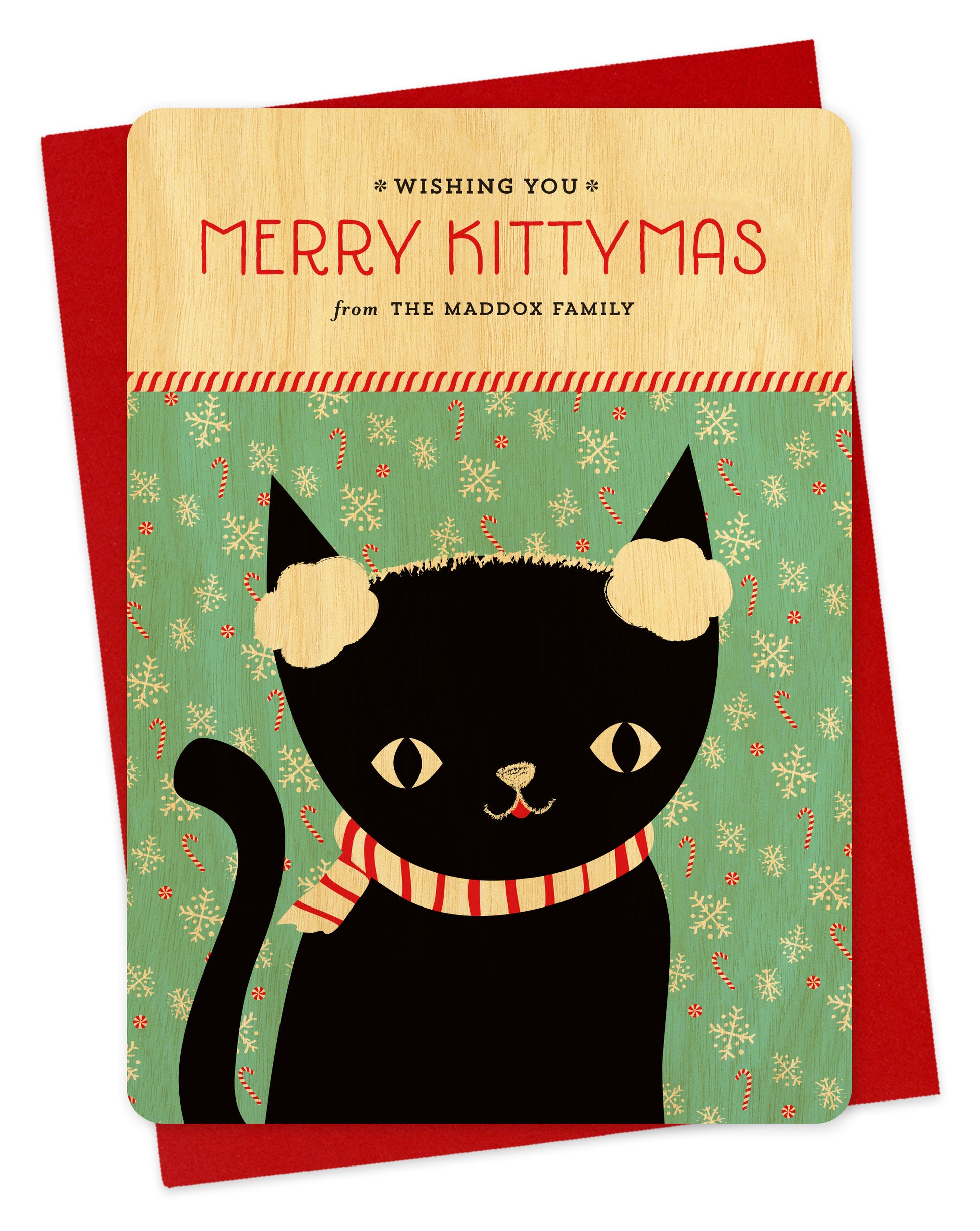 Customizable birch wood holiday card featuring a black cat wearing earmuffs in front of a festive backdrop, a "Merry Kittymas" sentiment and a personal greeting. Shown with a red envelope.