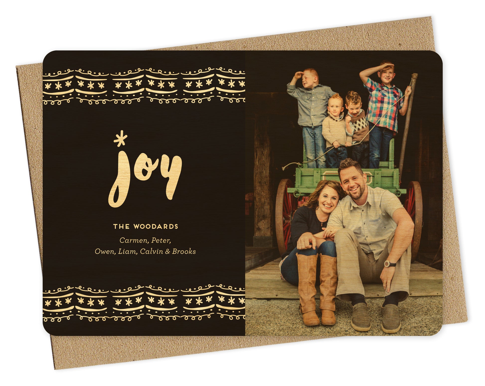 Customizable wood holiday card featuring a photo on the right and a bold black and white ric rac pattern with “joy” text and a personal greeting on the left. Shown with a kraft envelope.