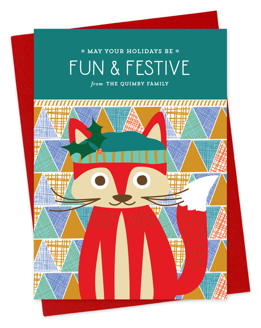 Customizable paper holiday card featuring a cute red fox wearing a stocking cap, “May Your Holidays Be Fun & Festive” text and a personal greeting on a colorful, geometric patchwork background. Shown with a red envelope.