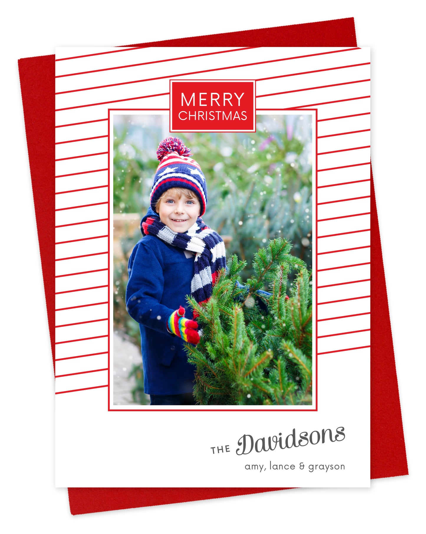 Customizable paper holiday card featuring a photo bordered by thin, diagonal red stripes, “MERRY CHRISTMAS” text near the top and a personal greeting near the bottom. Shown with a red envelope.
