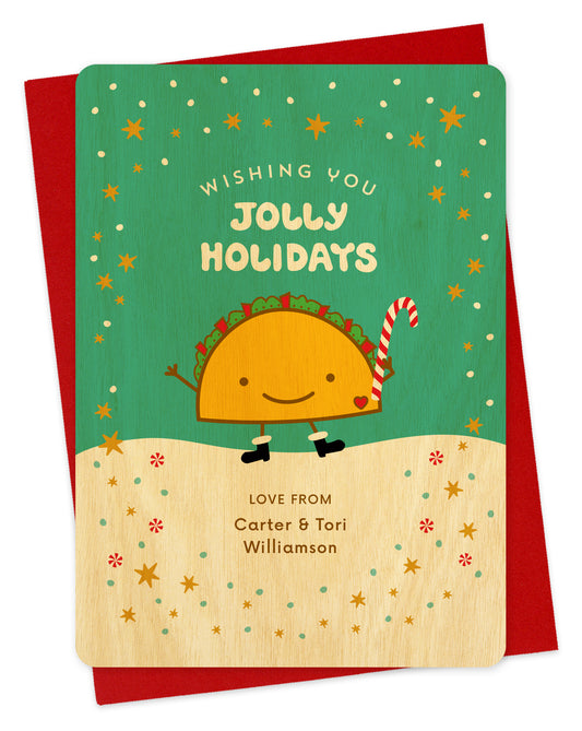 Customizable birch wood holiday card featuring a happy taco in front of a festive winter backdrop, a "Wishing You Jolly Holidays" sentiment and a personal greeting. Shown with a red envelope.