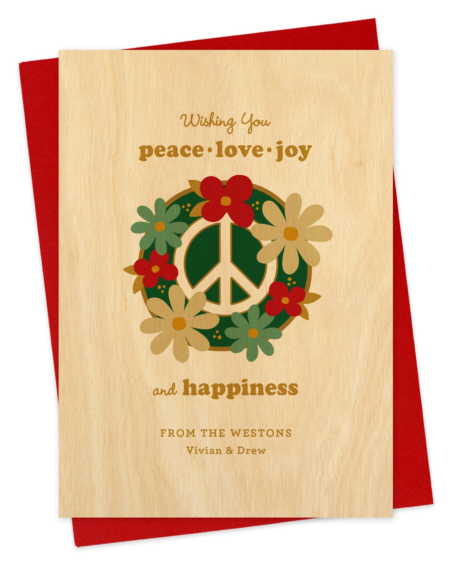 Customizable paper holiday card featuring a bold peace sign decorated with festive florals, a “Wishing you peace, love, joy and happiness” text and a personal greeting. Background is printed birch wood grain. Shown with a red envelope.