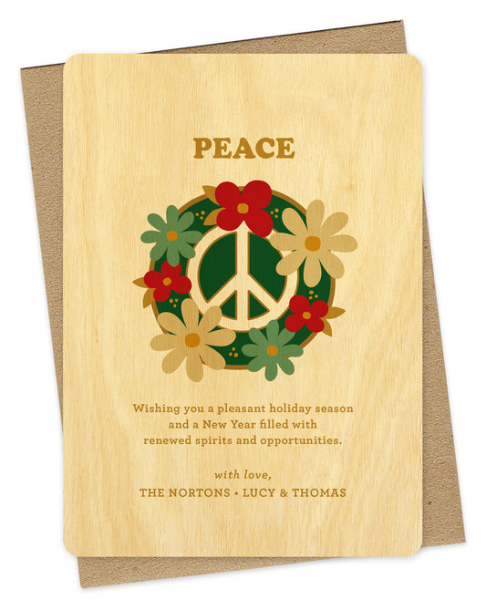 Customizable birch wood holiday card featuring a peace sign surrounded by colorful flowers with “Peace” text at the top and a personal greeting at the bottom. Shown with a kraft envelope.