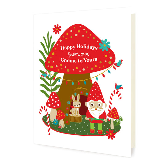 Front of folded holiday card featuring a cheerful gnome in a woodland scene with mushrooms, candy canes, birds, a rabbit and “Happy Holidays from Our Gnome to Yours” text.
