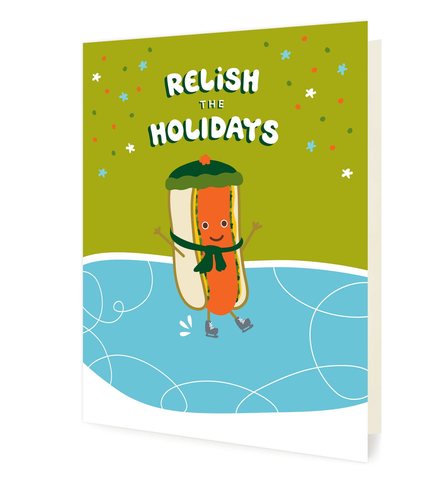Front of folded card with a cute illustrated hot dog wearing a stocking hat and scarf and ice skating. Card reads “Relish the Holidays” against a snowy green and blue background.