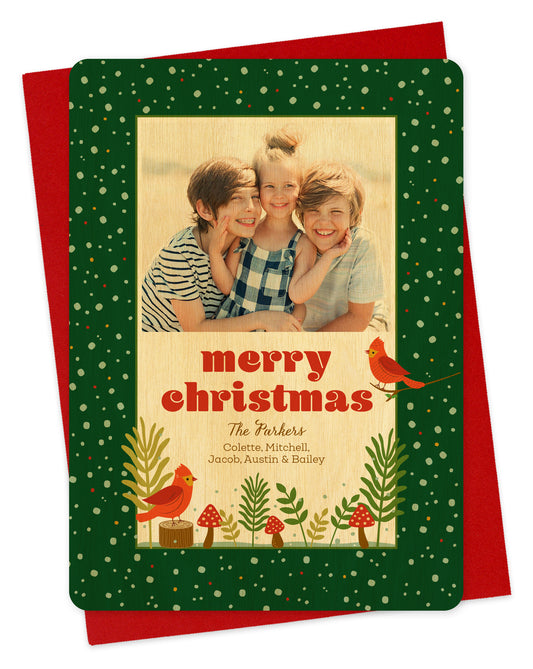 Personalized holiday card with cardinals and mushrooms on green background, printed on birch wood.