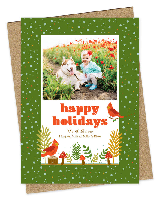 Customizable paper holiday card with a photo area, a woodland illustration of red birds and mushrooms and 'Happy Holidays' text on a kraft envelope.