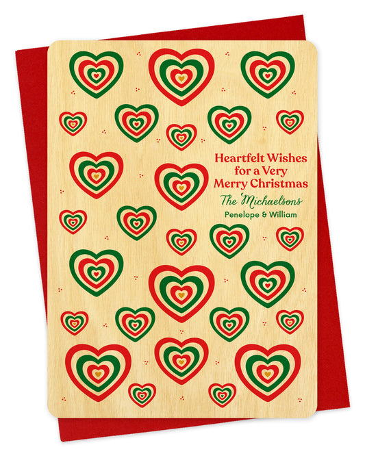 Customizable birch wood Christmas card with red and green heart patterns. Add your own personal greeting.