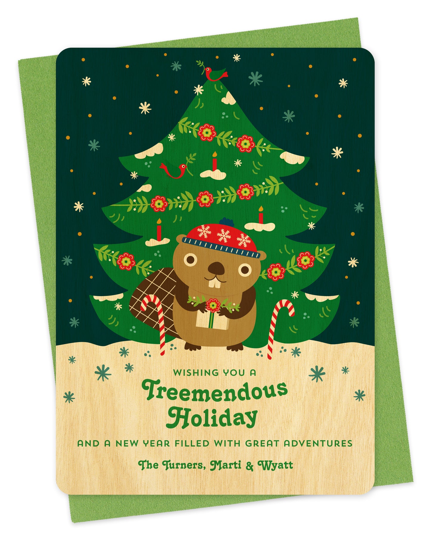 Customizable birch wood holiday card featuring a cute beaver holding a gift in front of a decorated outdoor Christmas tree, "Wishing you a Treemendous Holiday" text and a personal greeting at the bottom. Shown with a green envelope.