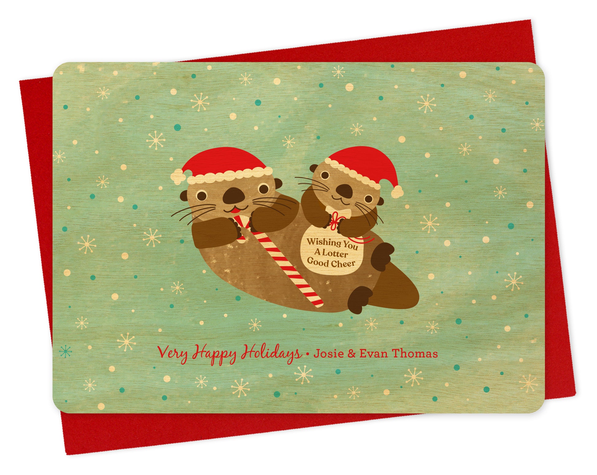 Customizable birch wood holiday card featuring two otters in Santa hats, one holding a candy cane and one with a “Wishing You A Lotter Good Cheer” bag on a snowy light blue background, along with a personal greeting. Shown with a red envelope.