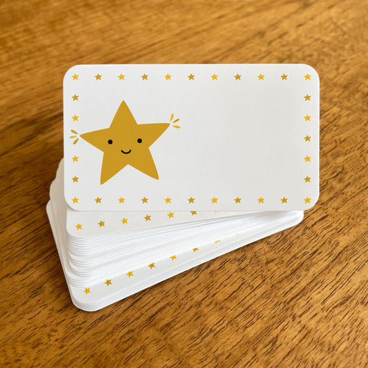 A stack of small white Gold Star note cards with rounded corners, featuring a cute smiling golden star surrounded by a border of small gold stars.
