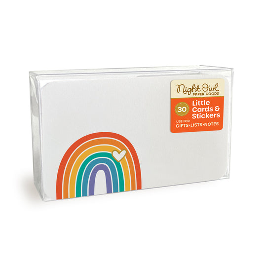 A clear plastic box displaying a small white note card with rounded corners featuring a colorful rainbow with a small heart. The box label reads “Night Owl Paper Goods - 30 - Little Cards & Stickers - Use for Gifts, Lists, Notes.”
