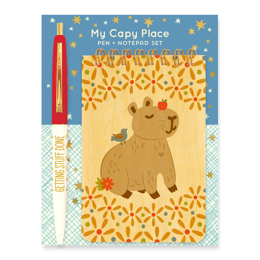 Gift Set that includes a Capybara Wood Mini Notepad + Getting Stuff Done ballpoint pen mounted on a blue backer card with white and gold foil stars.