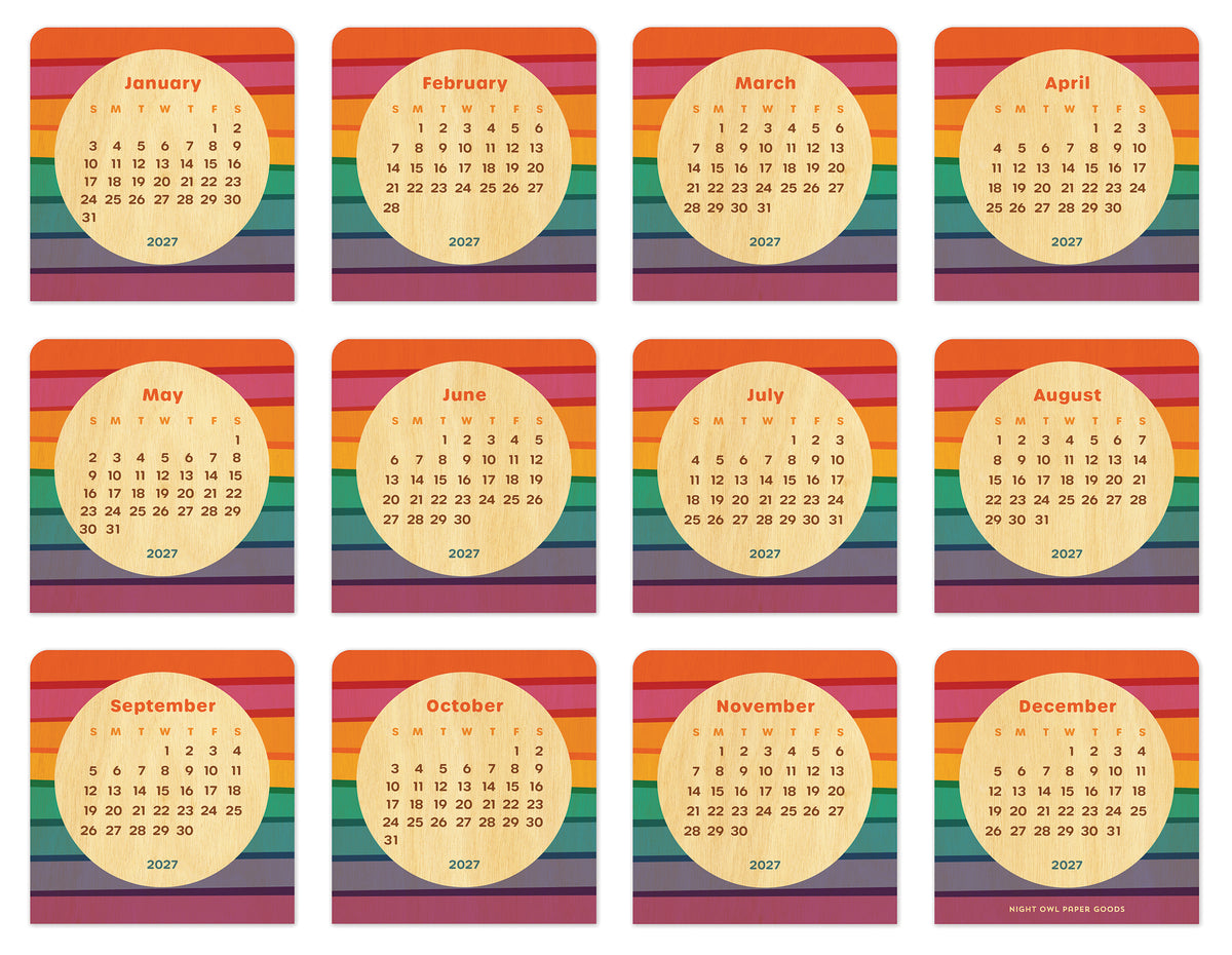 Birch wood mini desk calendar featuring bold horizontal rainbow stripes surrounding a natural birch wood circle with the month and dates. Calendar pages for all 12 months of 2027 are shown.