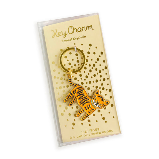 Tiger enamel keychain on gold foil stamped backer card packaged in a clear gift box. Backer card reads "Key Charm Enamel Keychain" at top and "Lil Tiger by Night Owl Paper Goods" at bottom.