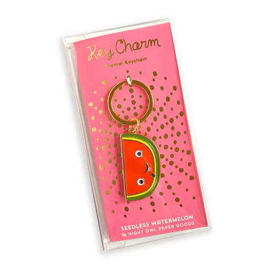 Watermelon slice enamel keychain on gold foil stamped backer card packaged in a clear gift box. Backer card reads "Key Charm Enamel Keychain" at top and "Seedless Watermelon by Night Owl Paper Goods" at bottom.