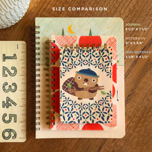 Size comparison of a journal, notebook and mini notepad with a wood ruler, showing dimensions for each.