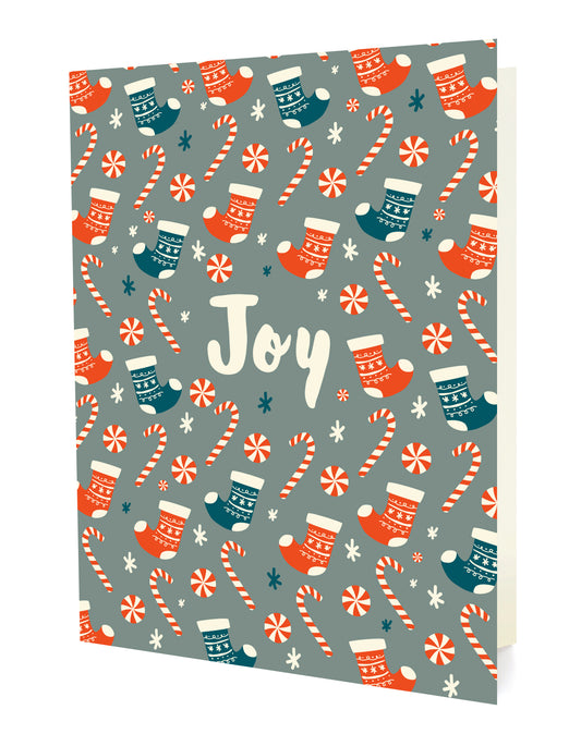 Front of folded holiday card featuring a festive pattern of stockings and candy canes surrounding “Joy” text on a gray background.