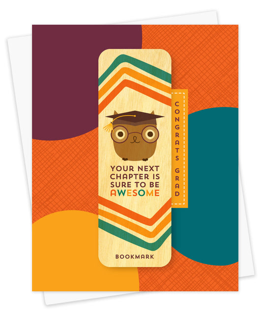 Folded graduation card with a colorful abstract design in orange, teal, gold and purple, with Congrats Grad text. Card includes a removable birch wood bookmark featuring an owl in a graduation cap and glasses and Your Next Chapter is Sure to Be Awesome text. Pictured with a white envelope.