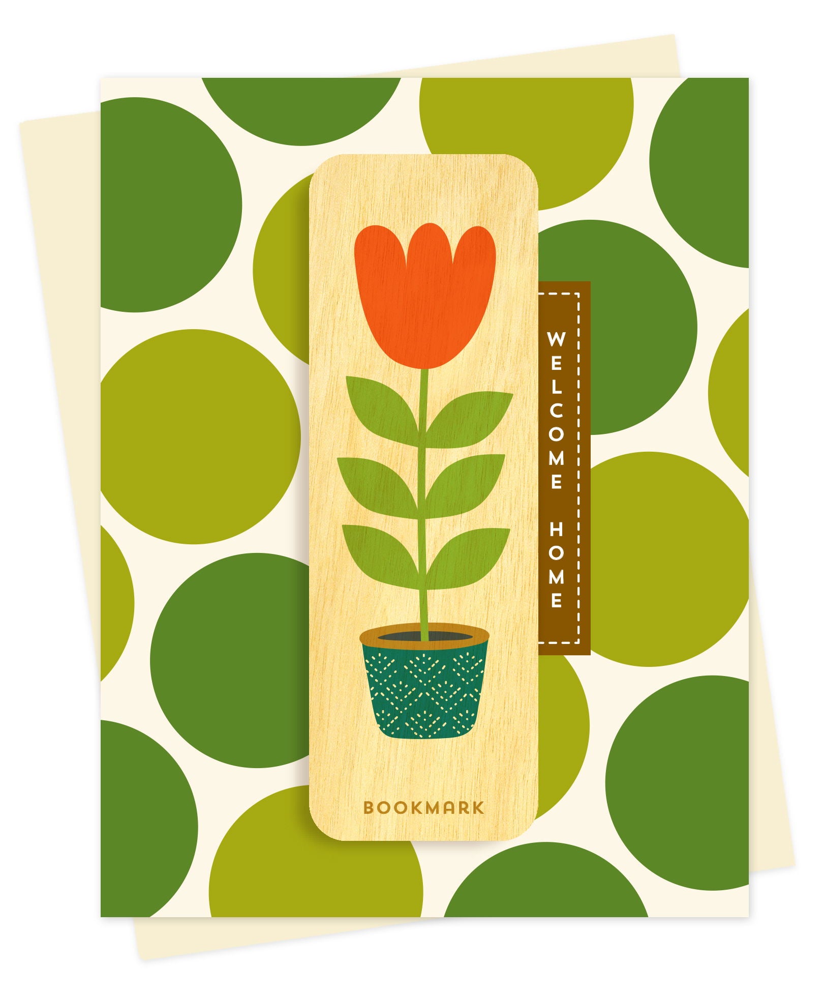 Folded new home card with a cream background and bold green polka dot pattern, with Welcome Home text and a removable birch wood bookmark featuring an orange tulip in a teal patterned pot. Pictured with a cream envelope.