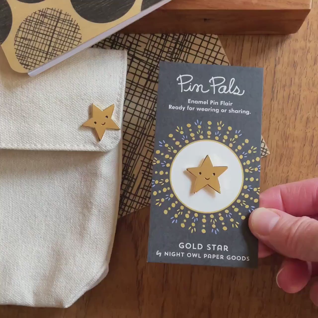 Front of enamel pin is a smiling gold star. Back of pin is gold with the Night Owl Paper Goods script logo. Pin is mounted on a backer card that says "Pin Pals - Enamel Pin Flair - Ready for wearing or sharing - GOLD STAR - by Night Owl Paper Goods" and is packaged in a clear bag.
