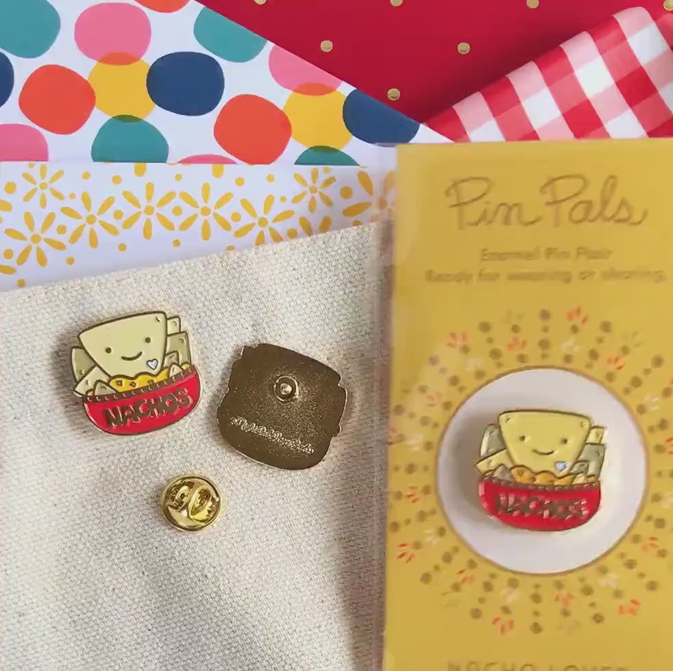 Front of enamel pin is a smiling bowl of nachos with gold accents. Back of pin is gold with the Night Owl Paper Goods script logo. Pin is mounted on a backer card that says "Pin Pals - Enamel Pin Flair - Ready for wearing or sharing - NACHO LOVER - by Night Owl Paper Goods" and is packaged in a clear bag.