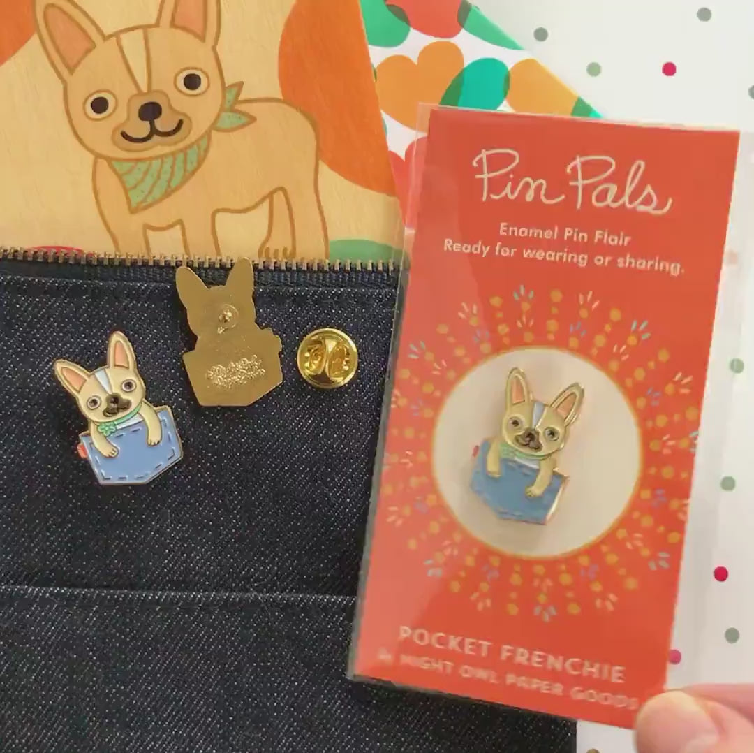 Front of enamel pin is a tan french bulldog popping out of a denim pocket with gold accents. Back of pin is gold with the Night Owl Paper Goods script logo. Pin is mounted on a backer card that says "Pin Pals - Enamel Pin Flair - Ready for wearing or sharing - POCKET FRENCHIE - by Night Owl Paper Goods" and is packaged in a clear bag.