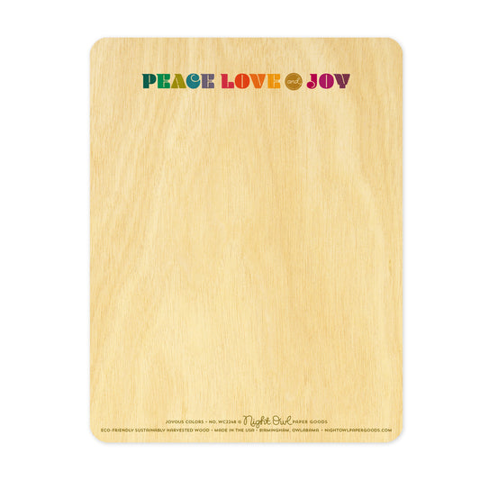 Back of Joyous Colors wood card, which is predominantly blank for a handwritten personal greeting. Along the top is colorful "PEACE LOVE and JOY" text. Along the bottom is the company logo and text that reads "Night Owl Paper Goods - eco-friendly sustainably harvested wood - made in the usa - birmingham, owlabama - nightowlpapergoods.com"